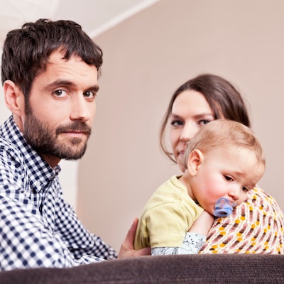 Vater, Mutter und Kind blicken gestresst