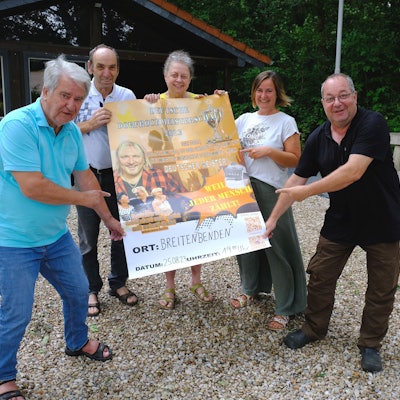 Die Vorstandsmitglieder des Bürgervereins Breitenbenden präsentieren ein Plakat, das für das Konzert mit Musiker Remo wirbt.
