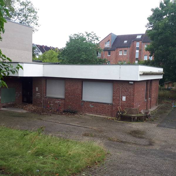Ein Flachbau mit roten Klinkern und heruntergelassenen Rollläden ist zu sehen.