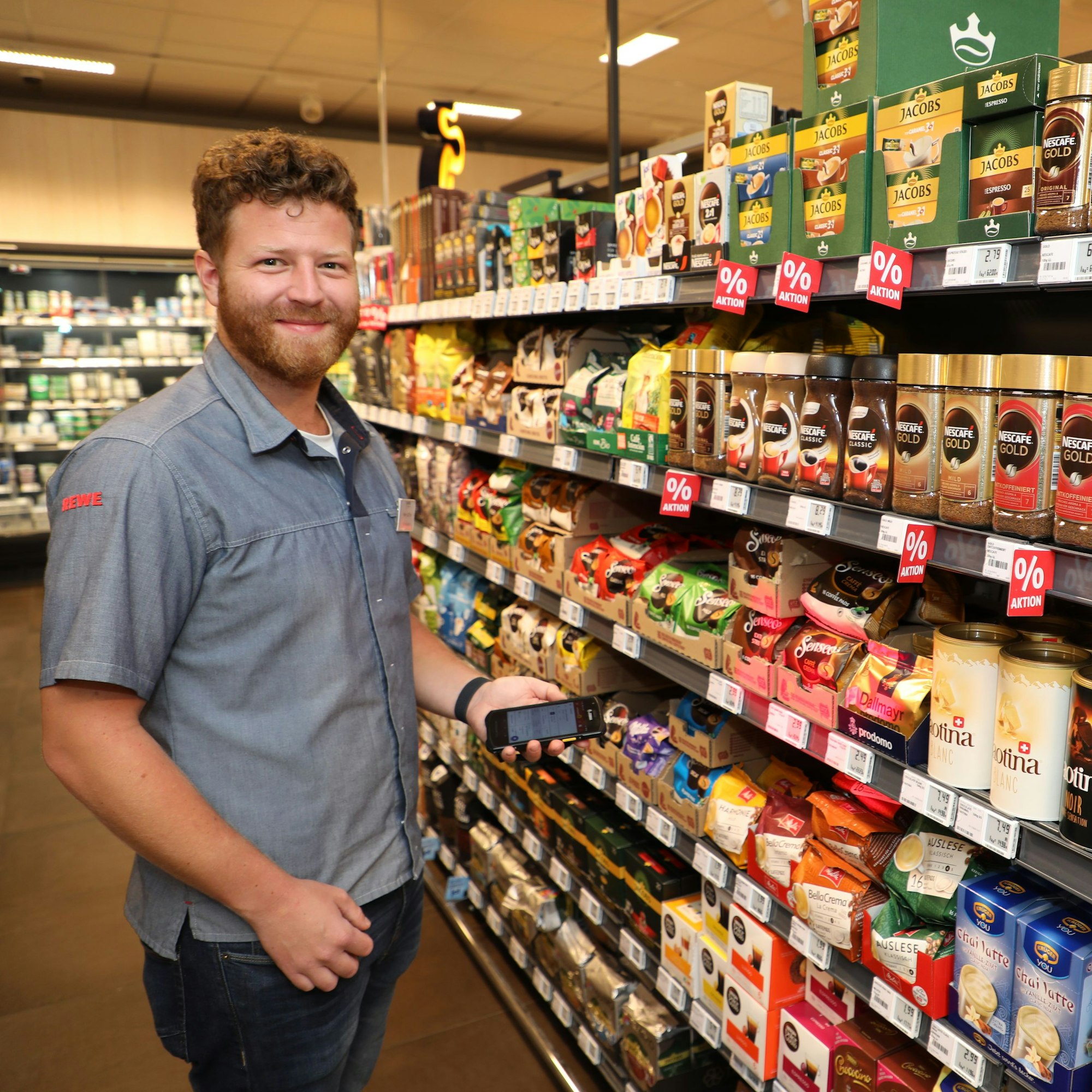 Daniel Küffler scannt mit einem Gerät in seiner Hand die Bestände der Waren im Supermarkt-Regal.