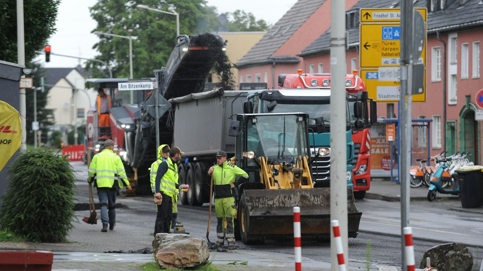 Baumaschinen sind auf einer teilweise abgefrästen Fahrbahn zugange.