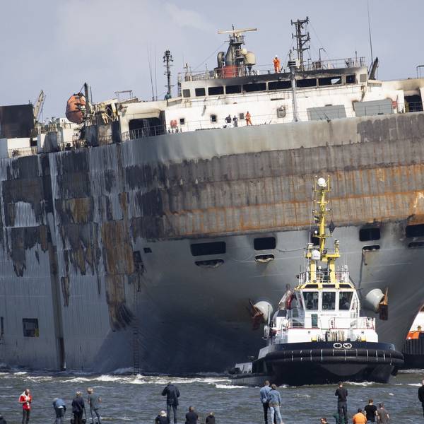 Der havarierte Nordsee-Frachter „Fremantle Highway“ wird von mehreren Schleppern in den Hafen von Eemshaven geschleppt. Das Schiff ist schwer beschädigt und in eine Richtung geneigt.