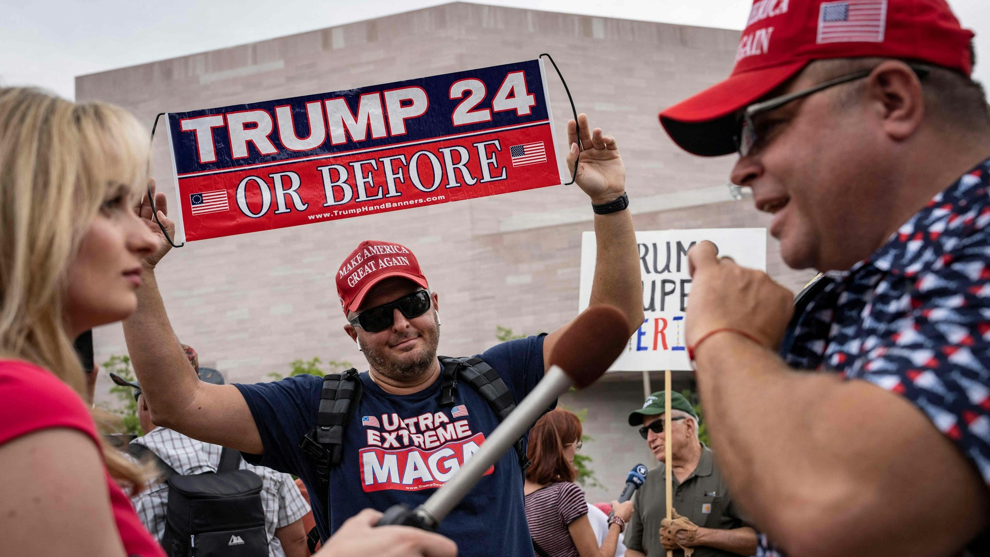 Ein Reporter interviewt Unterstützer des ehemaligen US-Präsidenten Donald Trump vor dem Gerichtsgebäude in Washington, DC.