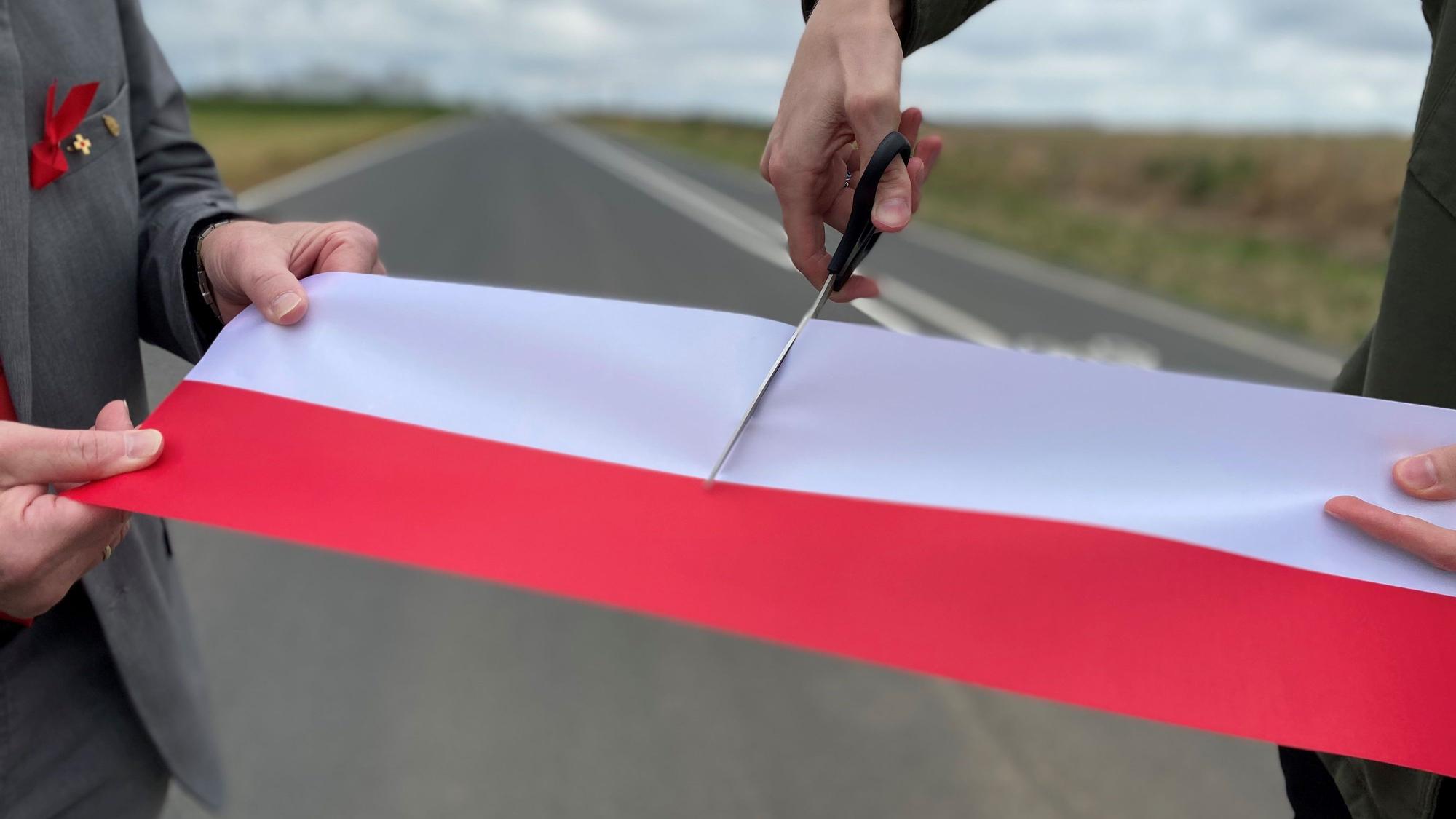 Das Bild zeigt den symbolischen Akt der Freigabe. Ein rot-weißes Band wird mit einer Schere durchgeschnitten.