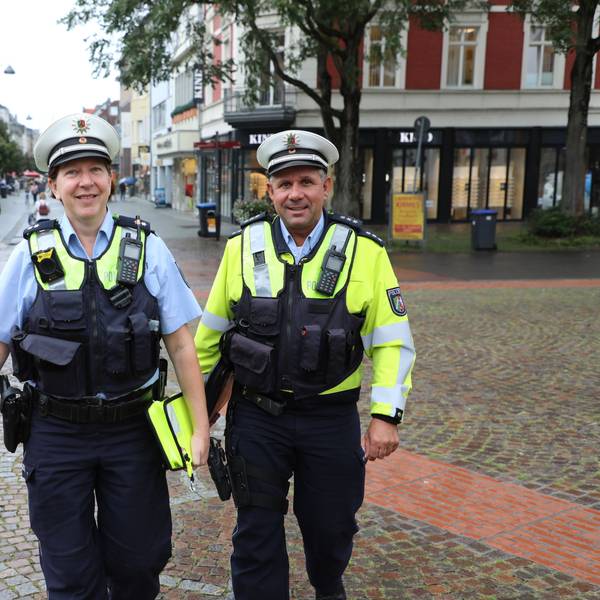 Zwei Bezirksbeamte der Polizei gehen durch die Bergisch Gladbacher Fußgängerzone.