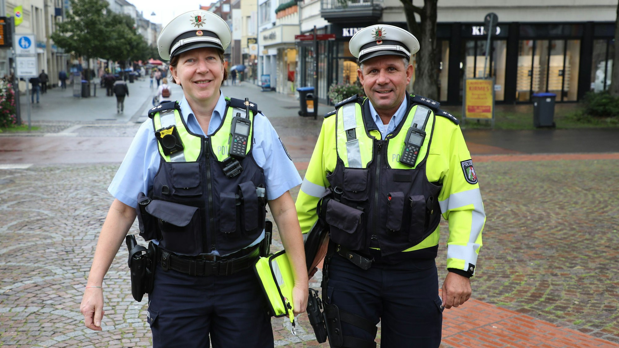 Zwei Bezirksbeamte der Polizei gehen durch die Bergisch Gladbacher Fußgängerzone.