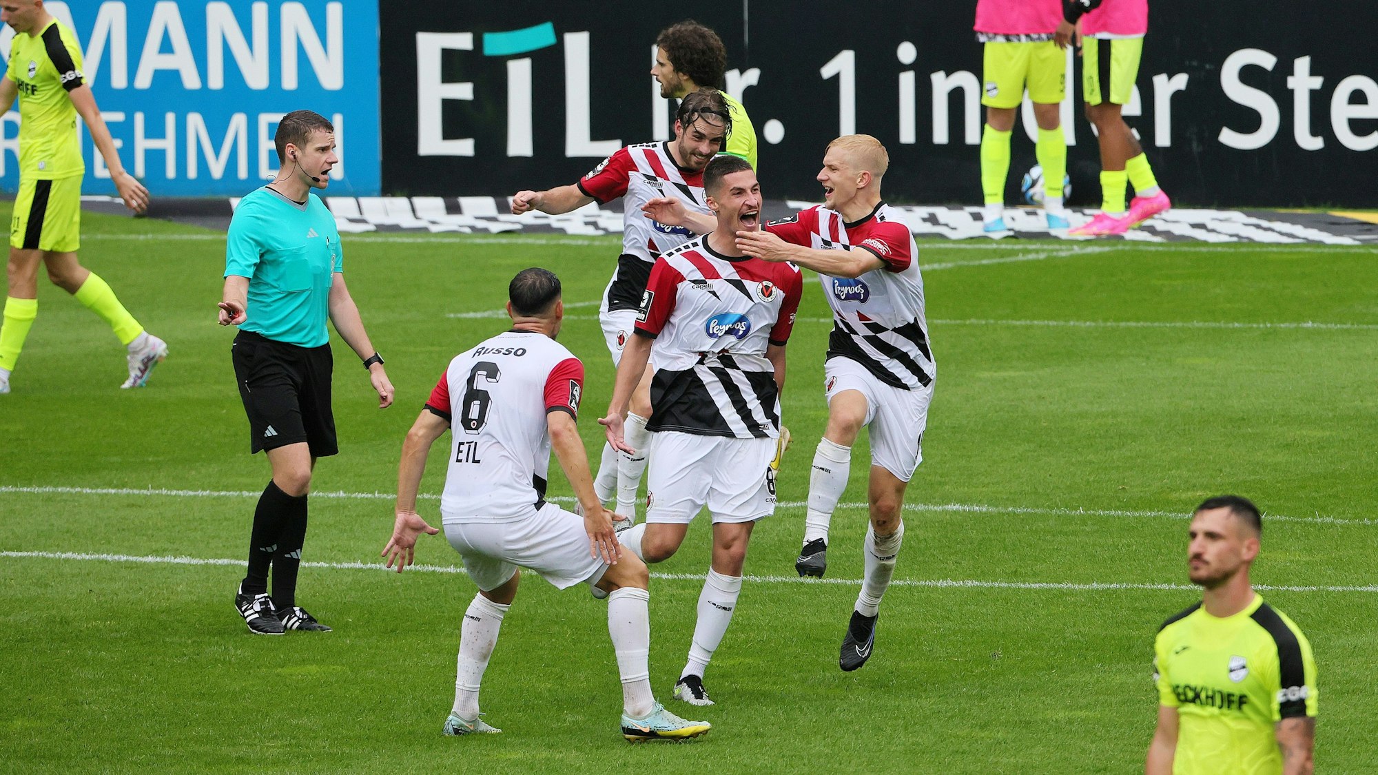 Die Spieler von Viktoria Köln freuen sich über ein Tor und feiern zusammen.