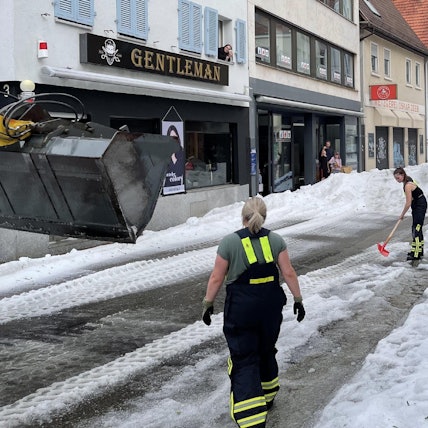 04.08.2023, Baden-Württemberg, Reutlingen: Einsatzkräfte der Feuerwehr räumen Hagel von einer Straße. Winterdienst-Einsatz mitten im Sommer: Ein lokal begrenztes Unwetter hat Straßen in der Innenstadt von Reutlingen mit einer hohen Hagel-Schicht überzogen. Foto: Schulz/SDMG/dpa +++ dpa-Bildfunk +++