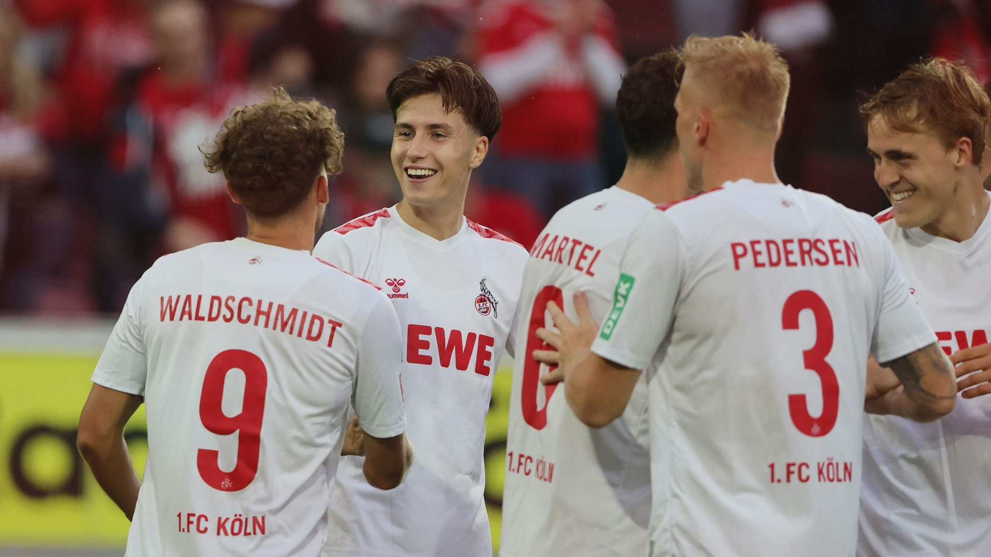 Mehrere Spieler des 1. FC Köln stehen zusammen und feiern ein Tor.