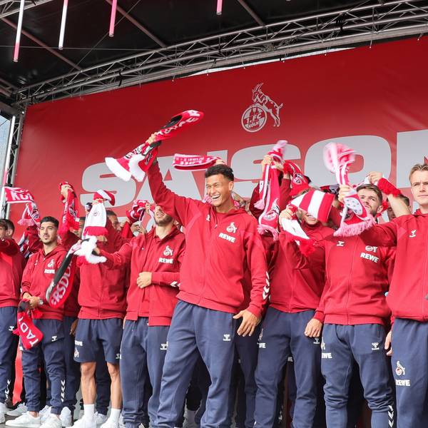 Die Mannschaft des 1. FC Köln singt die FC-Hymne auf einer Bühne.
