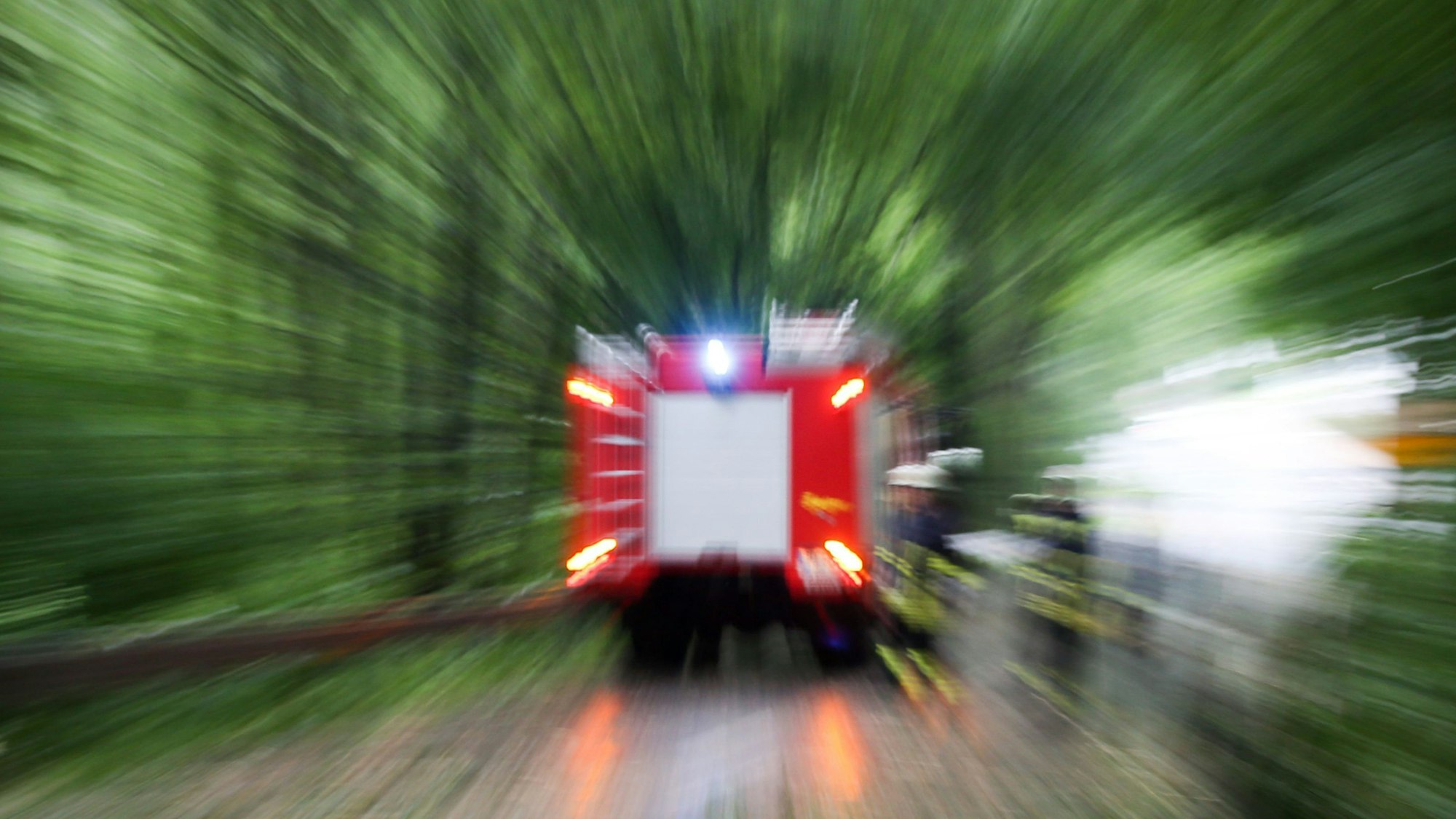 SYMBOLBILD - 19.07.2017, Nordrhein-Westfalen, Bielefeld: Feuerwehrleute räumen eine Straße, auf die Teile eines Baumes gefallen waren. (zu dpa "Viel Wind, wenig Regen - Gewitter ohne größere Schäden in Thüringen") Foto: picture alliance / Friso Gentsch/dpa +++ dpa-Bildfunk +++