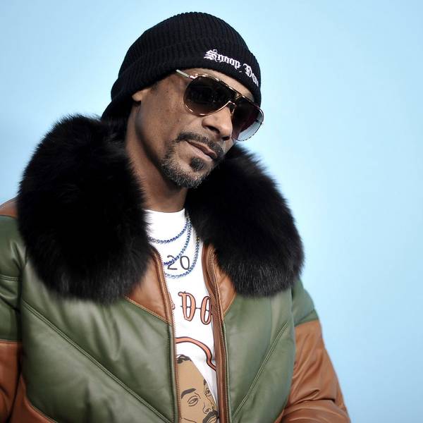 Snoop Dogg bei einer Filmpremiere. Er trägt Sonnenbrille und eine Jacke mit Pelzaufsatz.