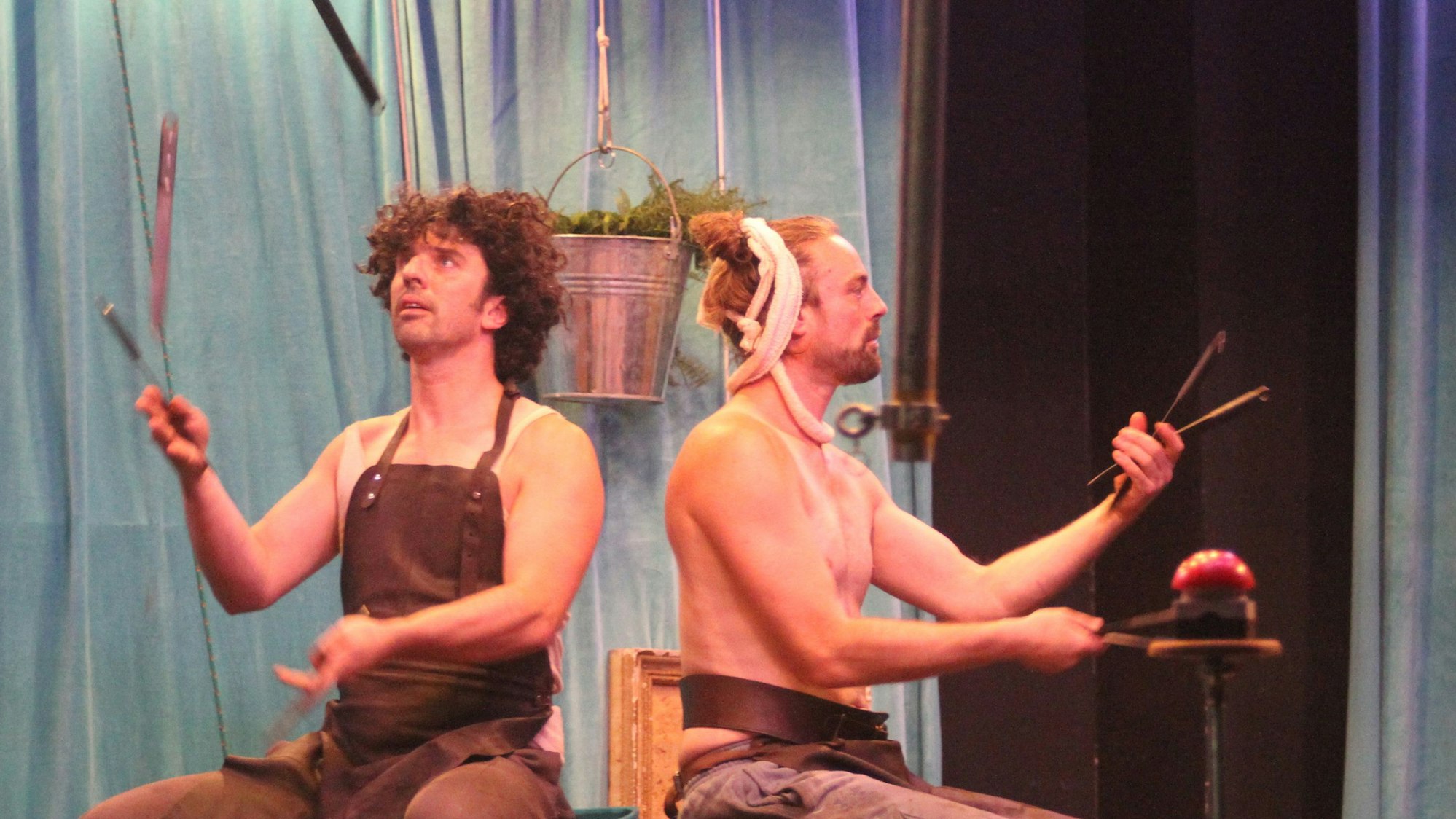 Straßentheater-Darsteller jonglieren im Sitzen mit Messern