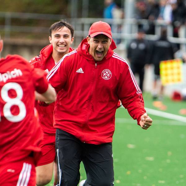 Das Bild zeigt Zülpichs Trainer David Sasse, der auf Torschütze Dominik Spies zuläuft, nachdem dieser ein Tor erzielt hat.