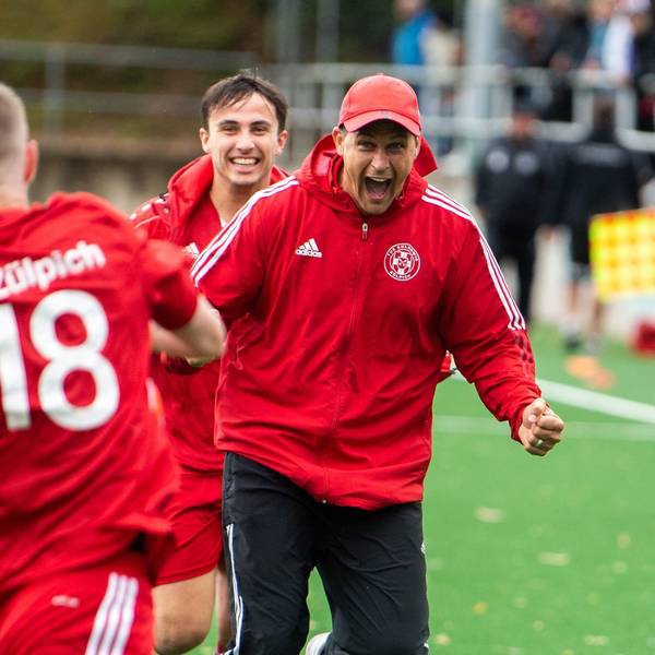 Das Bild zeigt den Zülpicher Trainer, der mit geballten Fäusten und aufgerissenem Mund auf seinen Spieler zuläuft.