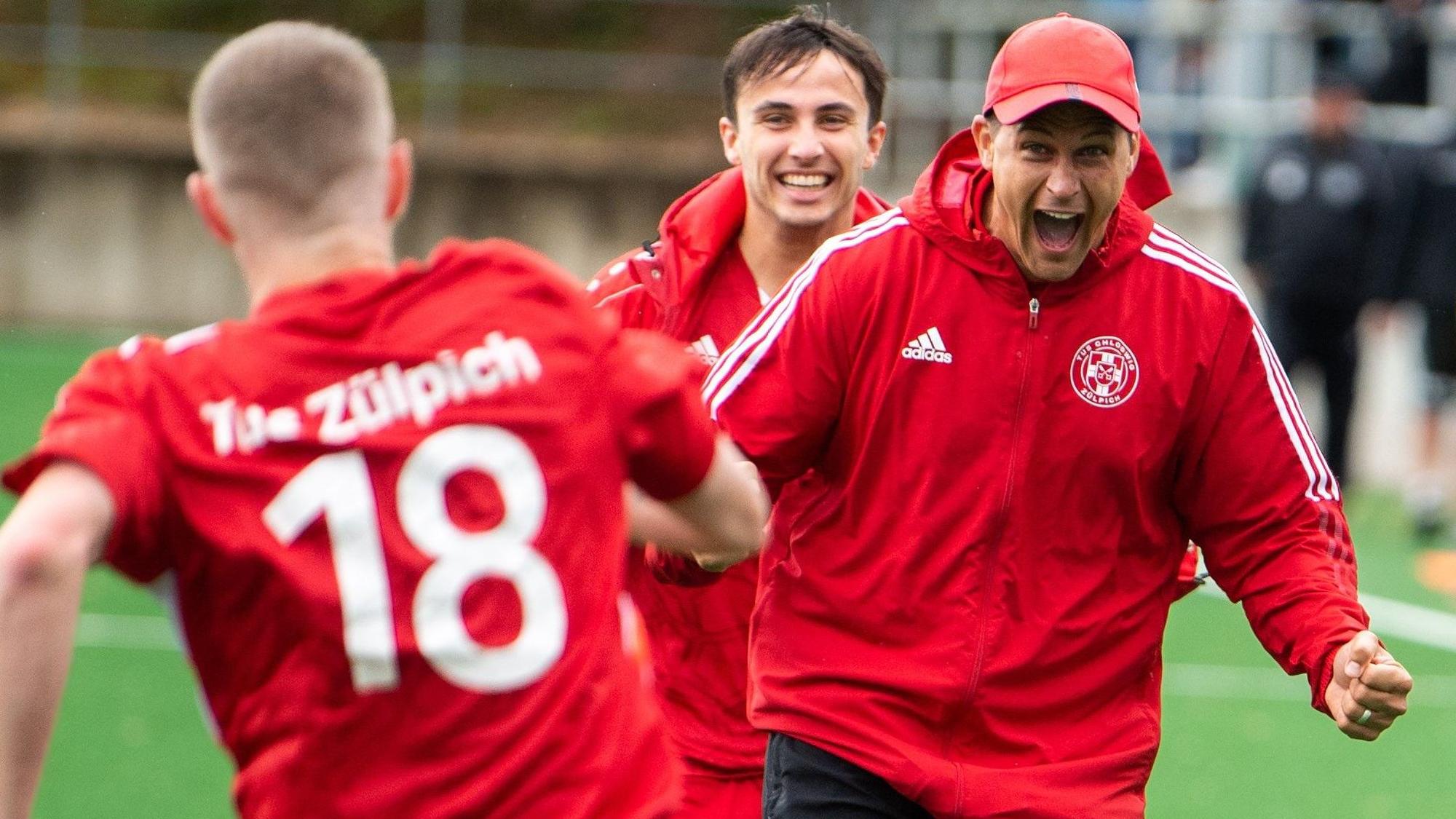 Das Bild zeigt den Zülpicher Trainer, der mit geballten Fäusten und aufgerissenem Mund auf seinen Spieler zuläuft.