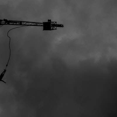 RECORD DATE NOT STATED A silhouette of a bungee jumper against a gloomy sky in grayscale *** einer Schattenriss des einer bungee Jumpen gegen einer d