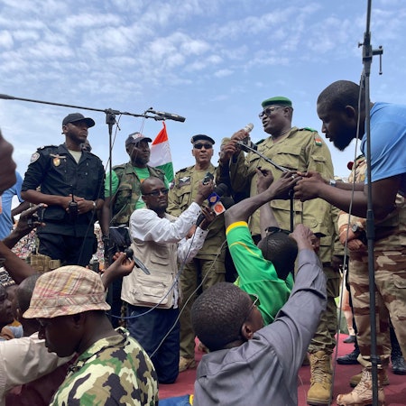 Einer der Soldaten, die den nigrischen Präsidenten Mohamed Bazoum gestürzt haben, spricht zu Anhängern der nigrischen Junta.