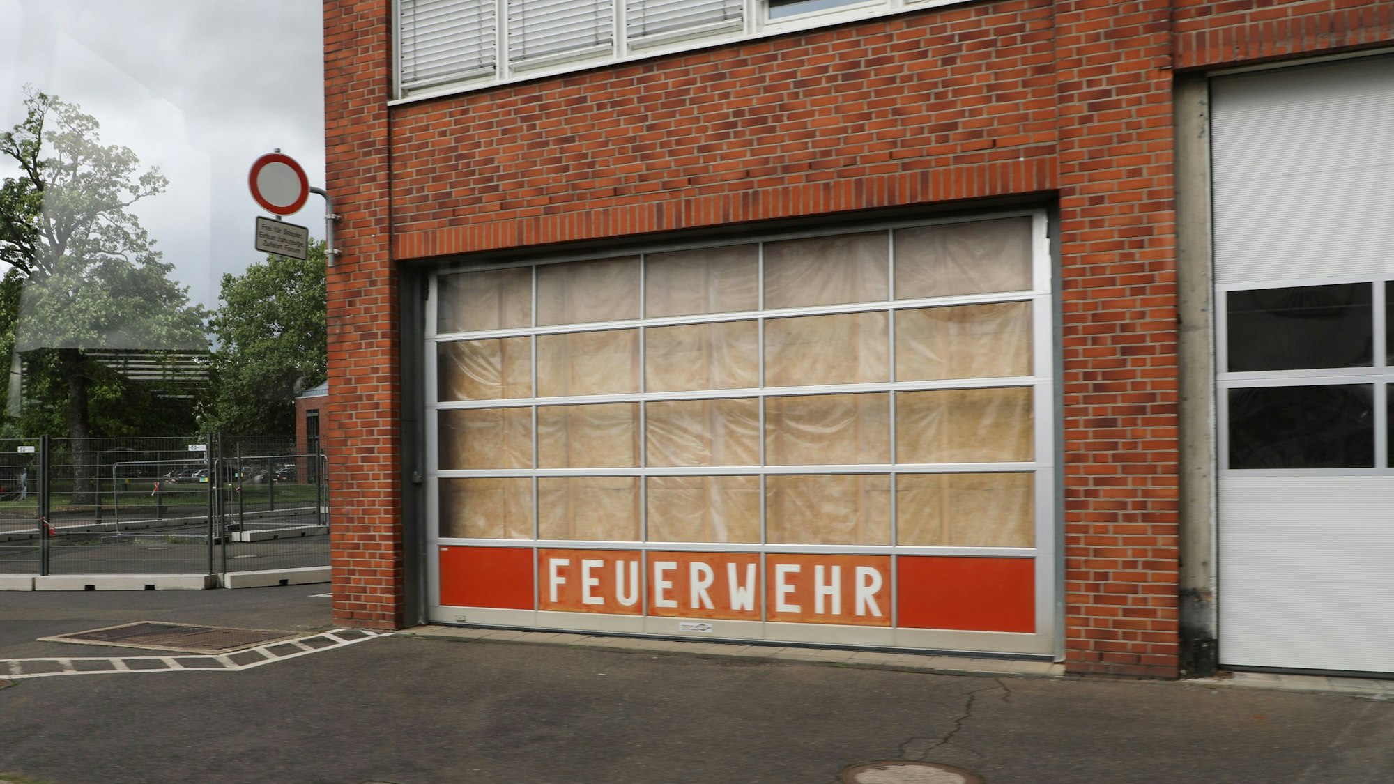Auf einem Rolltor eines Backsteingebäudes steht „Feuerwehr“.