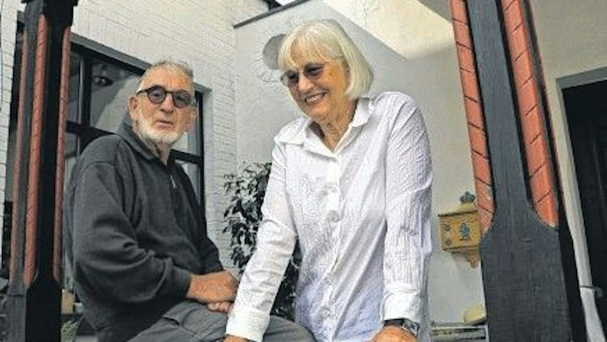 Ein Ehepaar vor einer historischen Wasserburg.