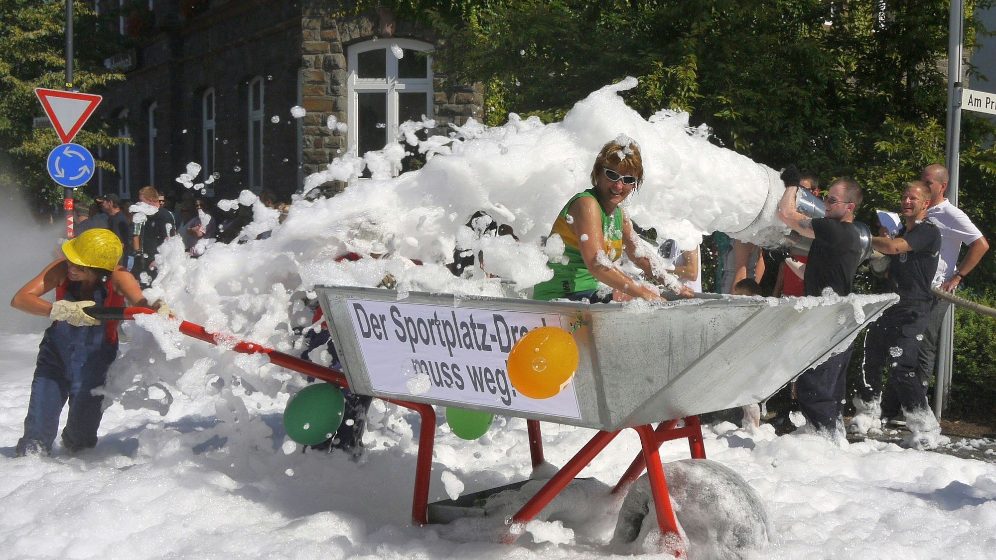Eine überdimensionale Schubkarre rollt während des Schubkarrenrennens in Morsbach am Rathaus der Gemeinde vorbei.