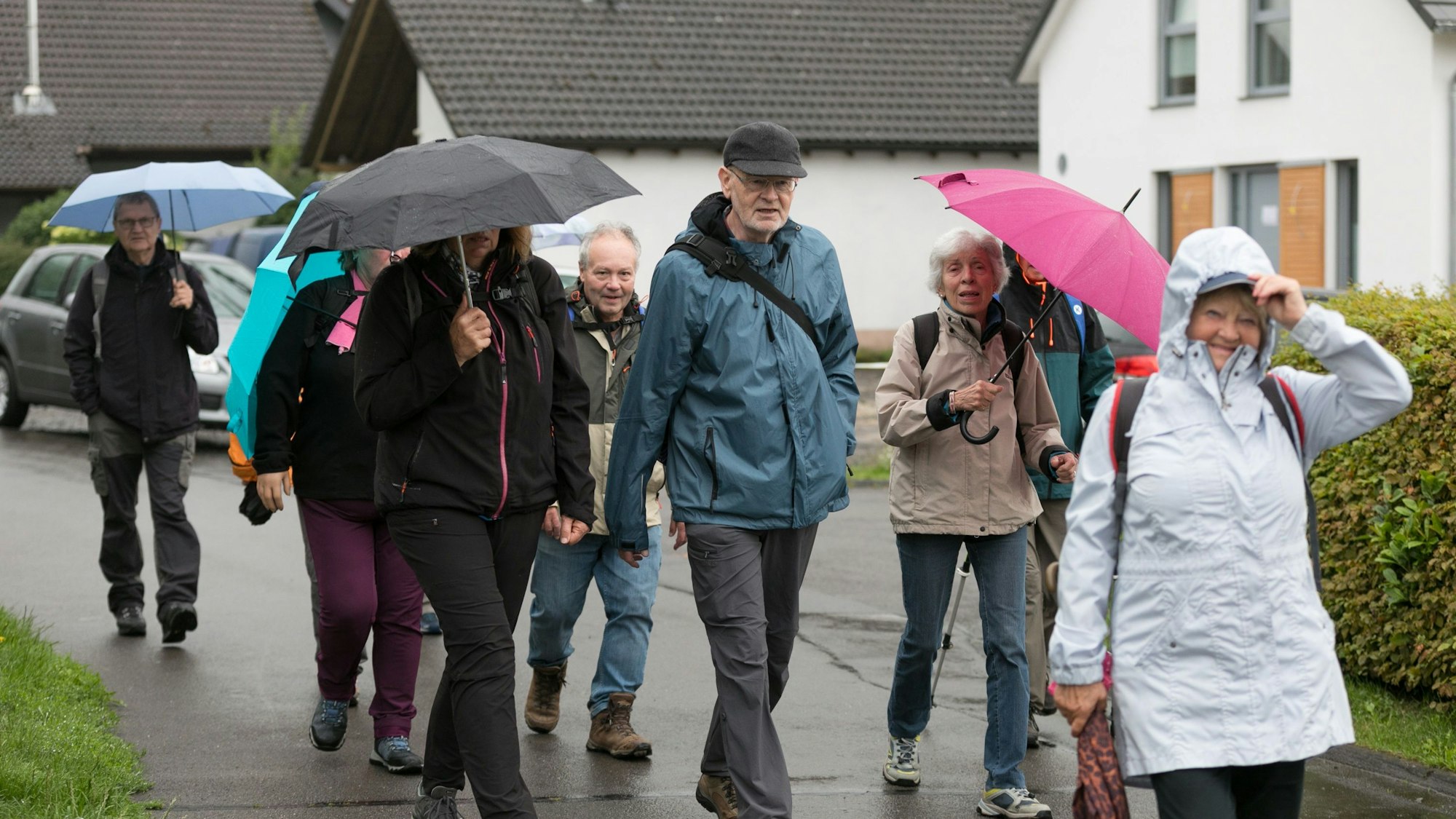 Mit Regenschirm und Regenjacken ausgerüstet trotzen die Wanderfreunde dem Regen.