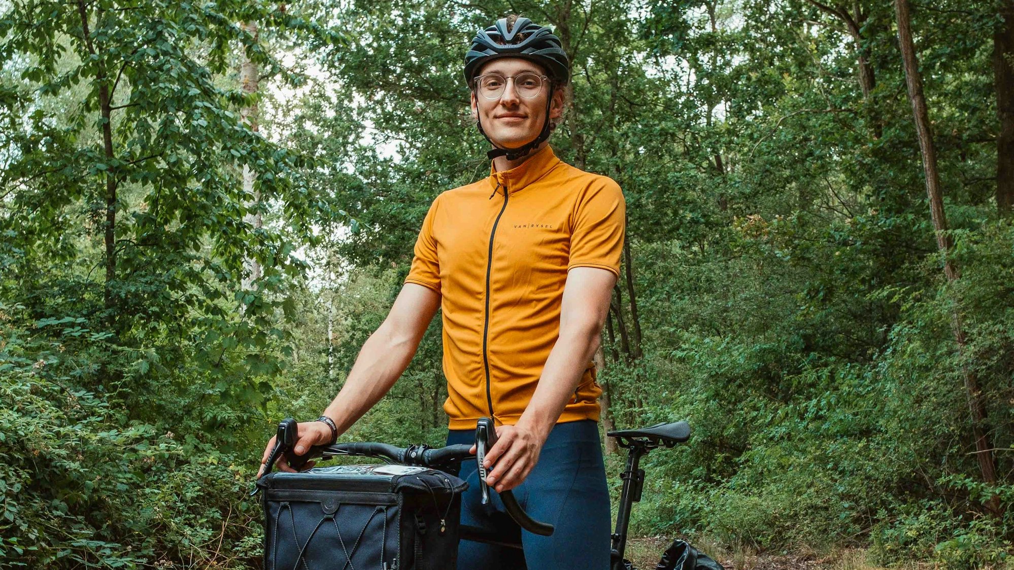 Ein junger Mann sitzt auf einem Fahrrad mit Packtaschen