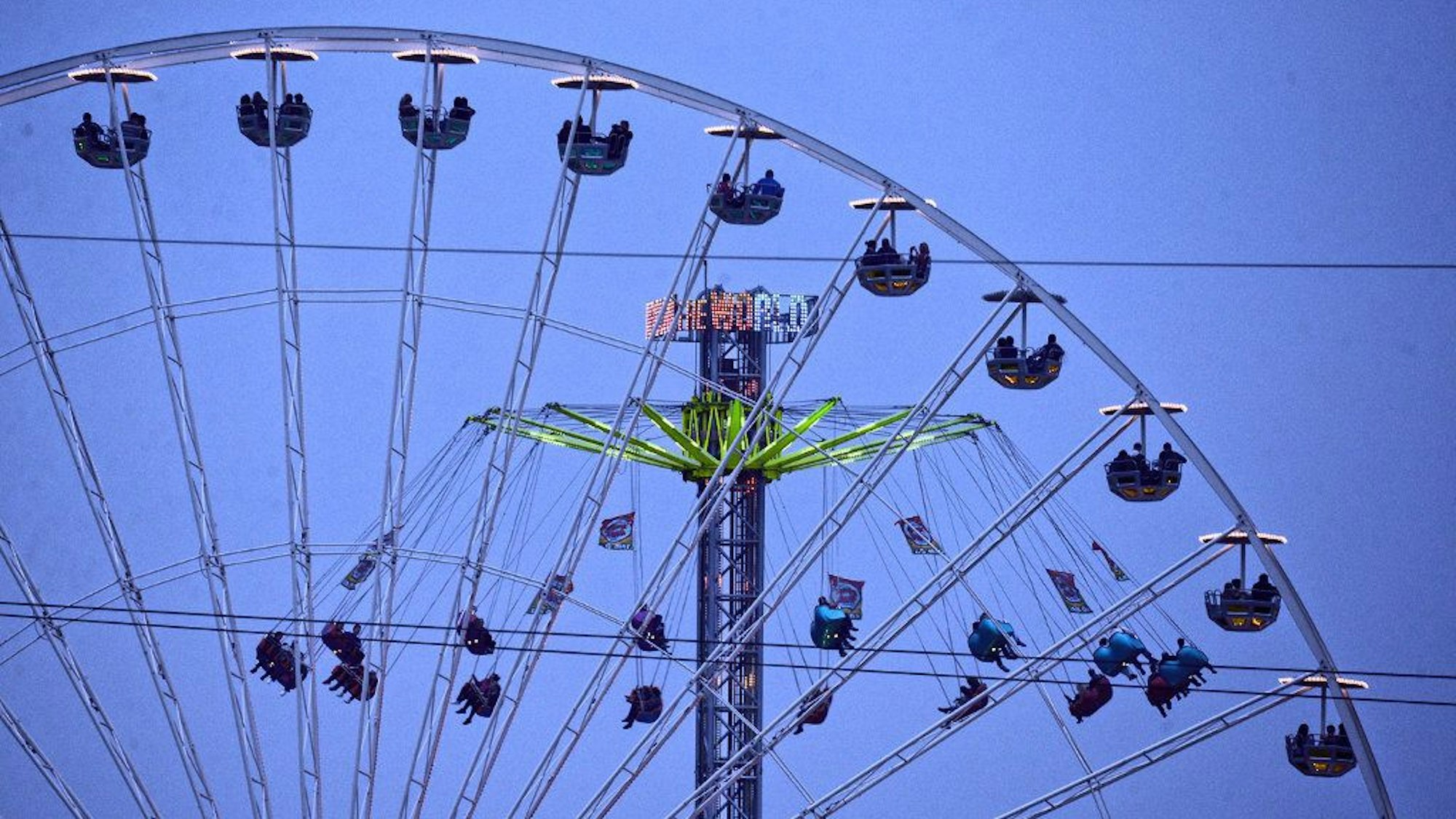 Ein Riesenrad und ein Kettenkarussell sind in Bonnbeim Jahrmarkt „Pützchens Markt“ zu sehen.