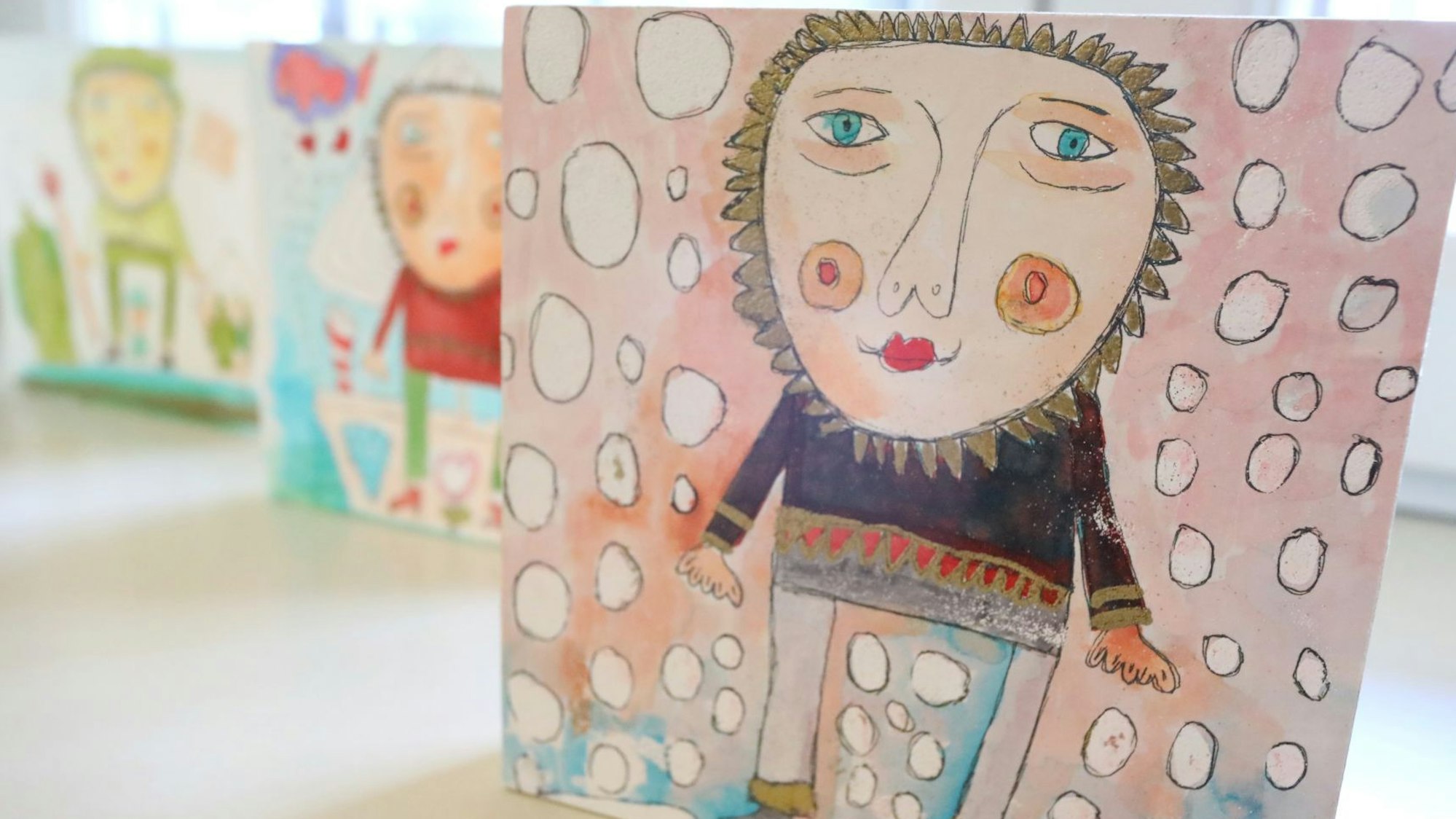 Drei Bilder zeigen bunte Figuren.