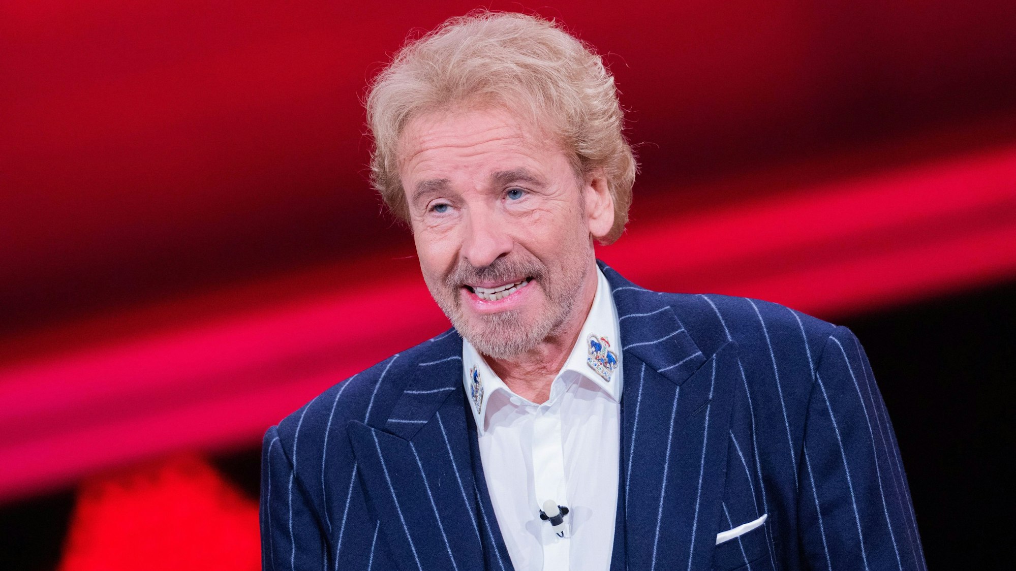 „Wetten, dass..?“-Moderator Thomas Gottschalk steht in Anzug vor einer roten Bühne. Er war 2022 als Moderator der Kultsendung zurückgekehrt.