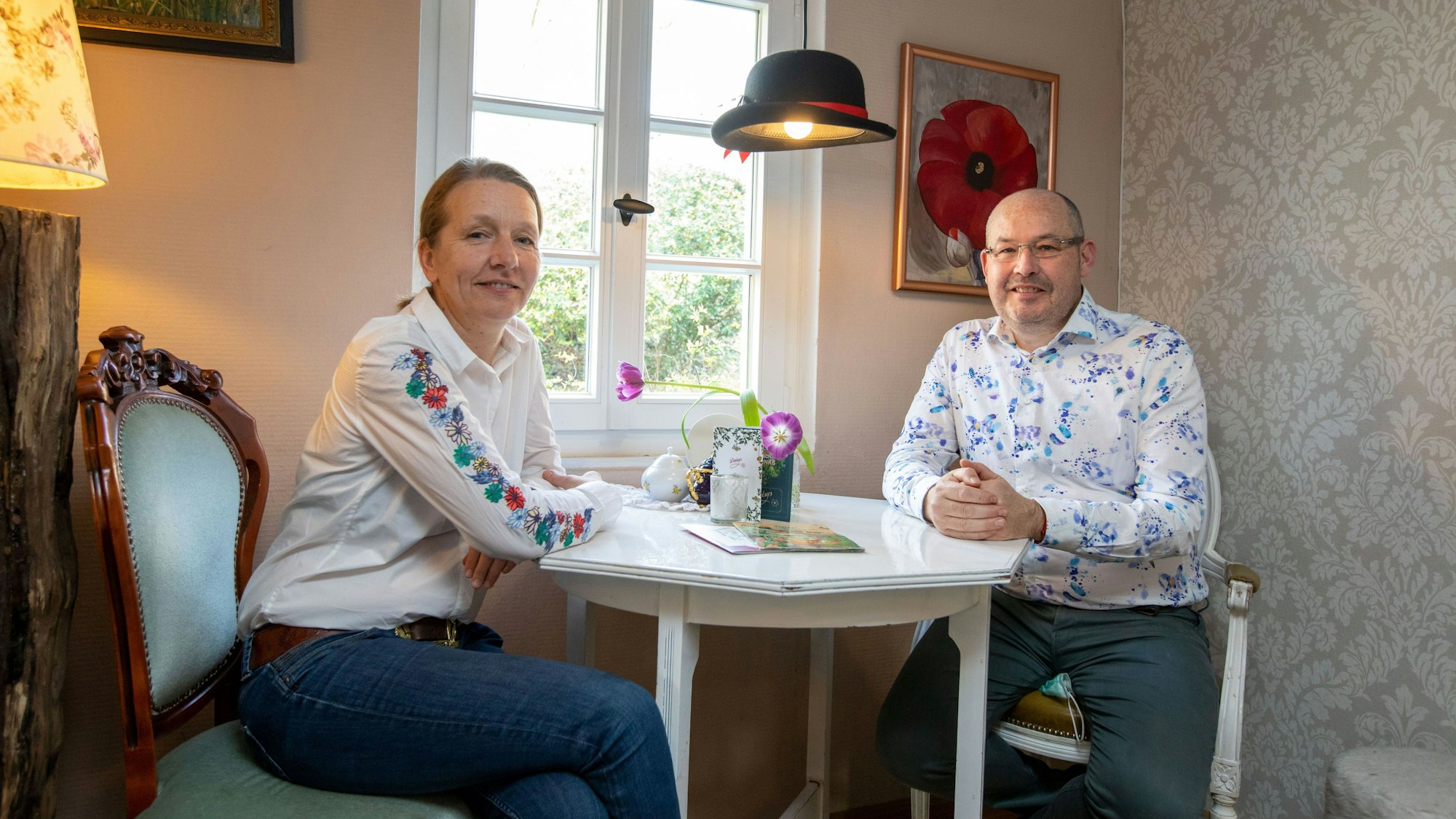 Zwei Leute sitzen im Café am Tisch.