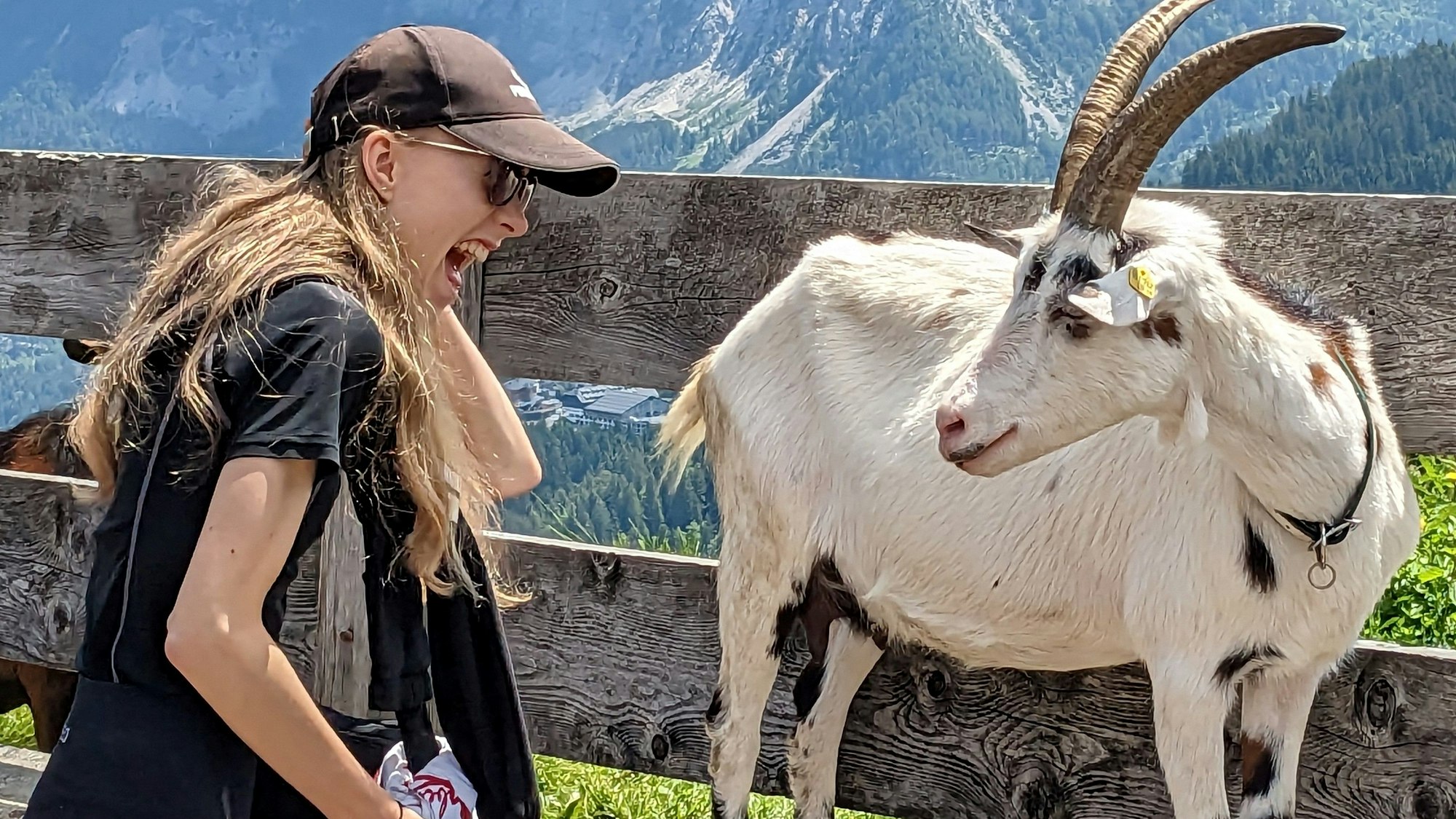 Lucy Ebke, Tochter des Fotografen, daneben eine Ziege. Im Hintergrund sind Berge zu sehen.