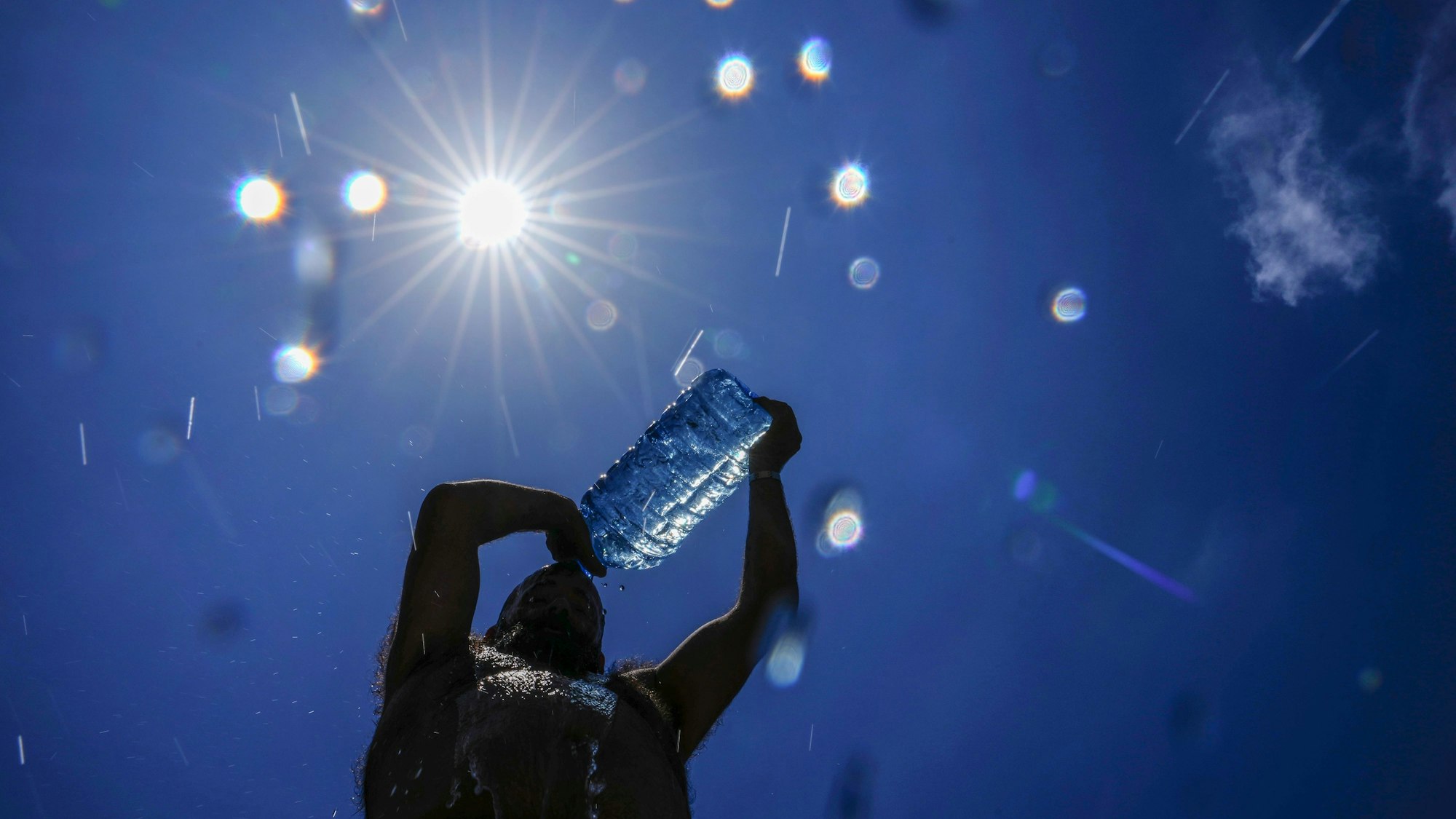FILE - A man pours cold water onto his head to cool off on a sweltering hot day in the Mediterranean Sea in Beirut, Lebanon, July 16, 2023. European climate monitoring organization made it official: July 2023 was Earth's hottest month on record by a wide margin. (AP Photo/Hassan Ammar, File)