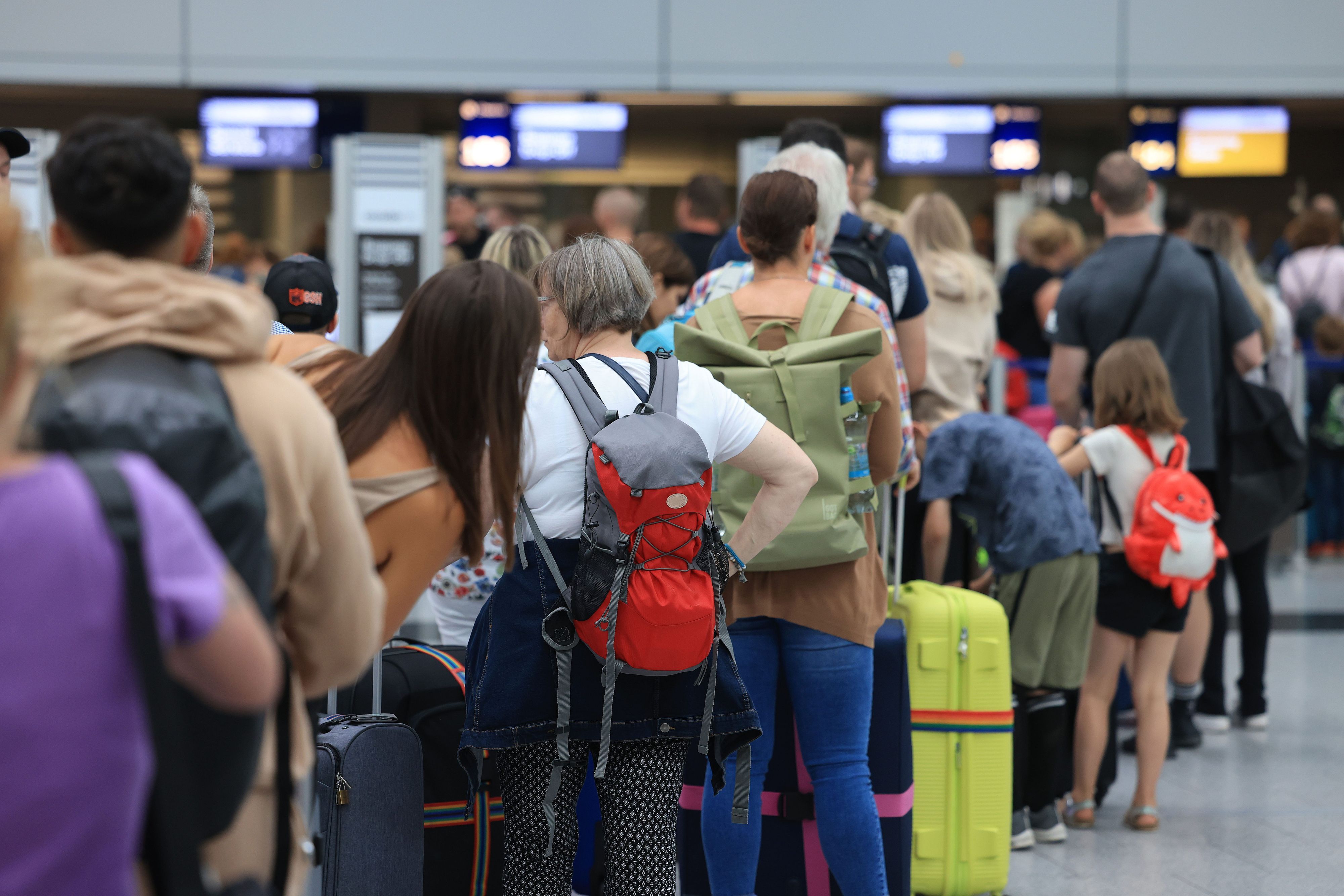 Reisende stehen am Flughafen Düsseldorf in einer Warteschlange. An  deutschen Flughäfen läuft der Flugverkehr im Sommer 2023 stabiler als im chaotischen Vorjahr. (Symbolbild)