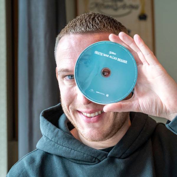 Mo-Torres hält sich eine CD vor ein Auge.