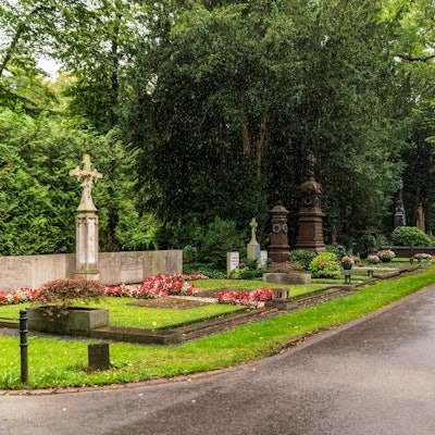 Der Melaten-Friedhof in Köln. Auf der linken Seite stehen Gräber.