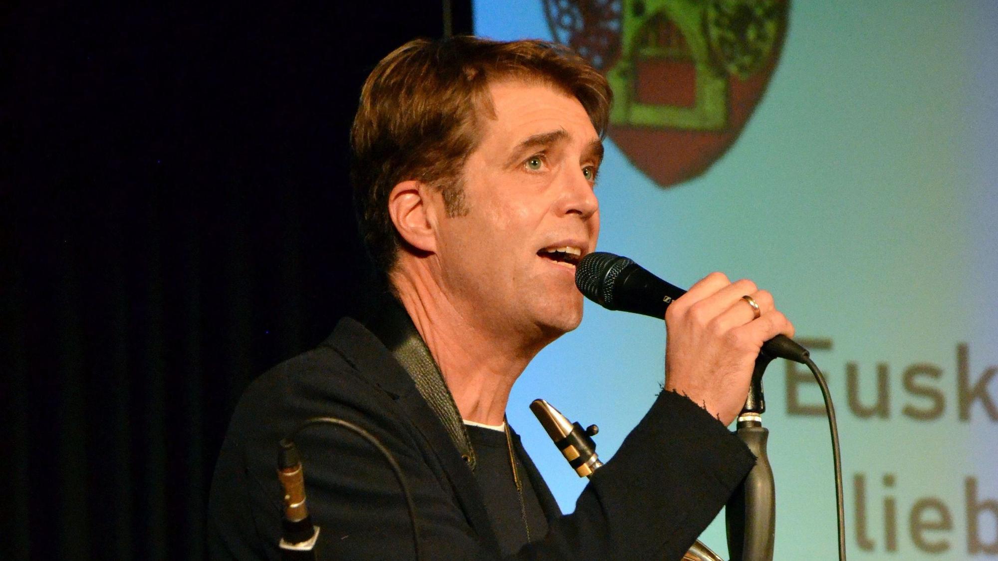 Michael Luke, Gründer der Blue Mary Big Band, spricht in ein Mikrofon.
