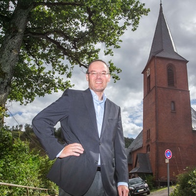 Pfarrer Marc Platten steht vor der Kirche der Emmaus-Kirchengemeinde in Wiedenest-Derschlag.