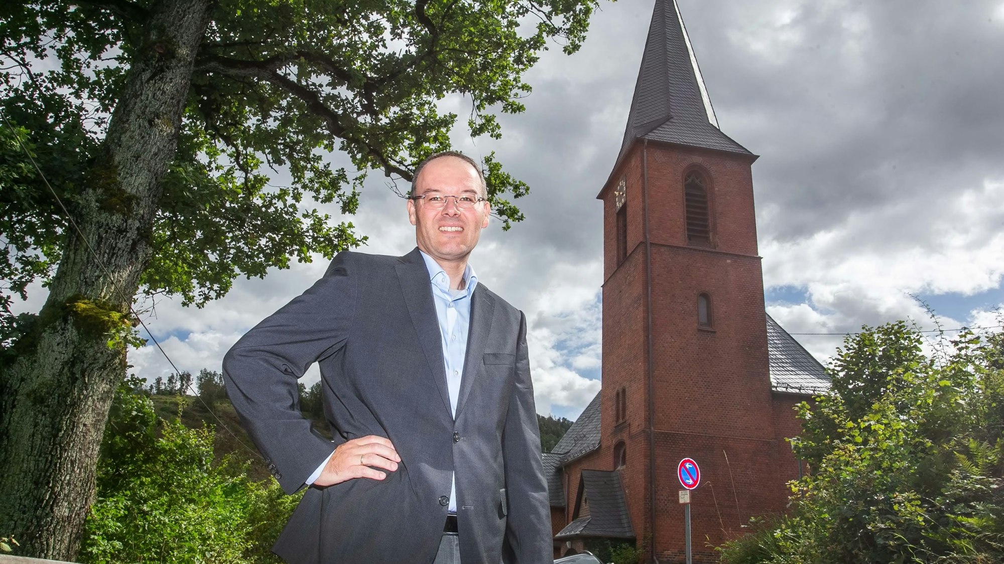Pfarrer Marc Platten steht vor der Kirche der Emmaus-Kirchengemeinde in Wiedenest-Derschlag.
