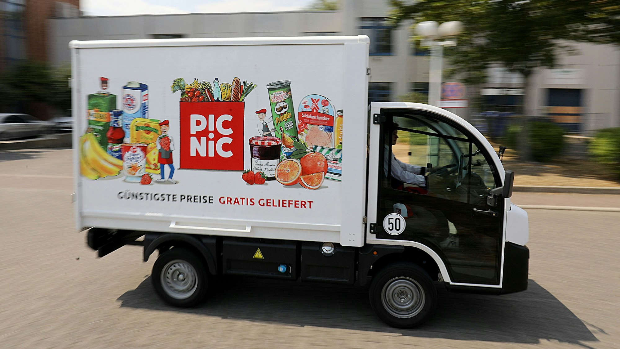 Einer der in die Höhe ragenden Elektro-Vans wird von einem Fahrer gesteuert.