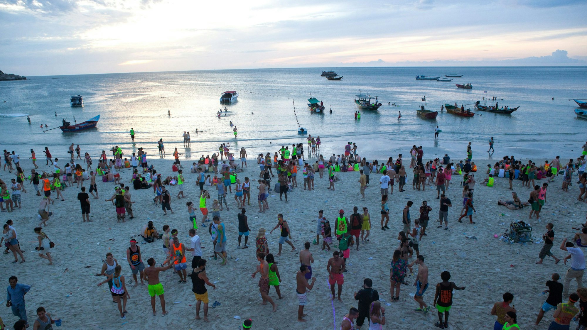 Feiernde stehen am Haad Rin Beach und beobachten den Sonnenaufgang nach einer durchfeierten Nacht während der monatlichen Vollmondparty auf der Insel Koh Phangan im Süden Thailands (Symbolbild). Auf eine solche Party wollte auch der Tatverdächtige mit seinem Freund gehen, doch dazu kam es nicht mehr.