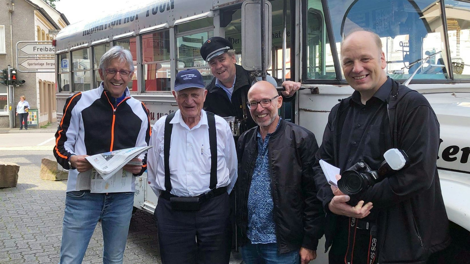 Menschen stehen vor einem historischen amerikanischen Schulbus im Ortskern von Rösrath-Hoffnungsthal.