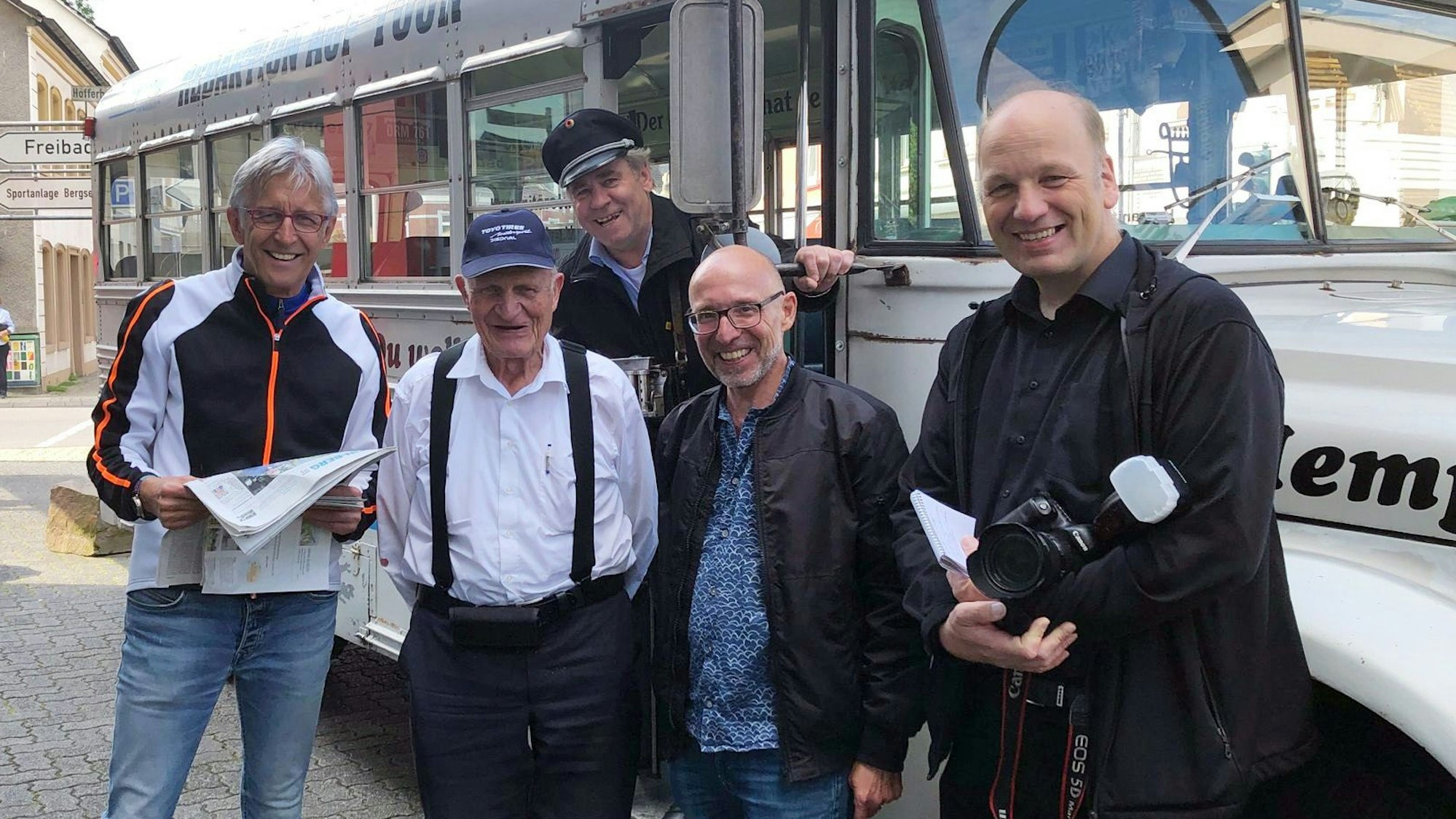 Menschen stehen an einem historischen amerikanischen Schulbus.