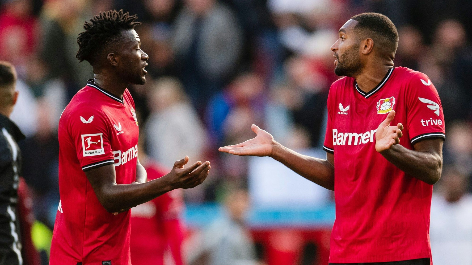 Leverkusens Edmond Tapsoba (l) und Jonathan Tah diskutieren.