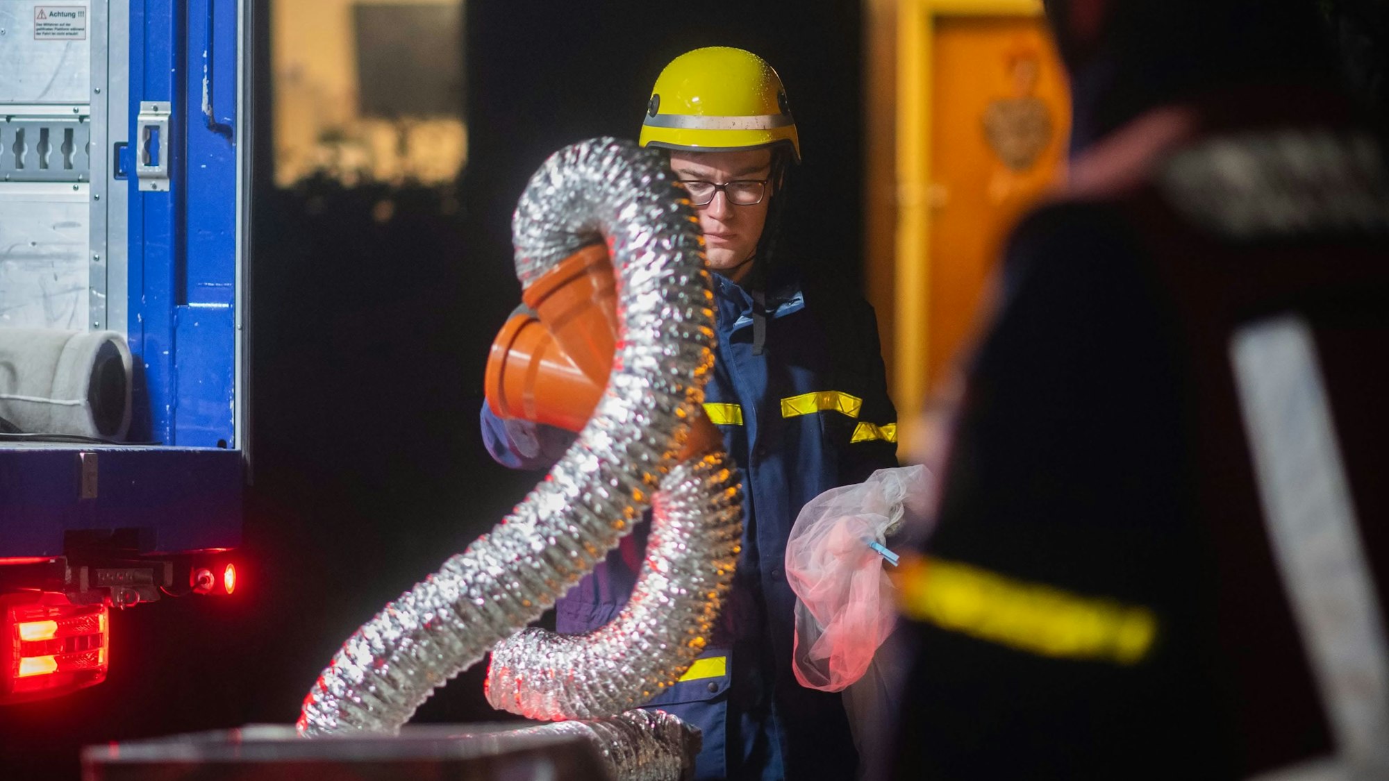 Ein THW-Mitarbeiter in Einsatzkleidung trägt silberfarbene Schläuche. Sie gehörten zu einer in Euskirchen entdeckten Marihuana-Plantage.