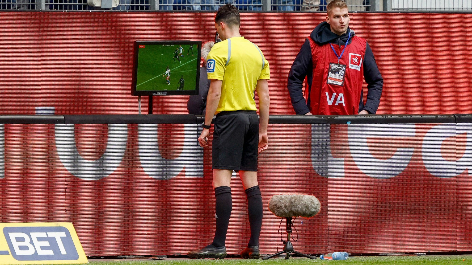 Schiedsrichter Florian Badstuber schaut sich nach dem Anruf des VAR eine Spielszene auf dem Bildschirm an.