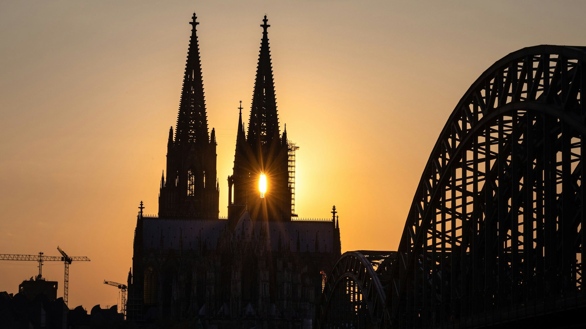 Die Sonne geht hinter dem Kölner Dom auf.