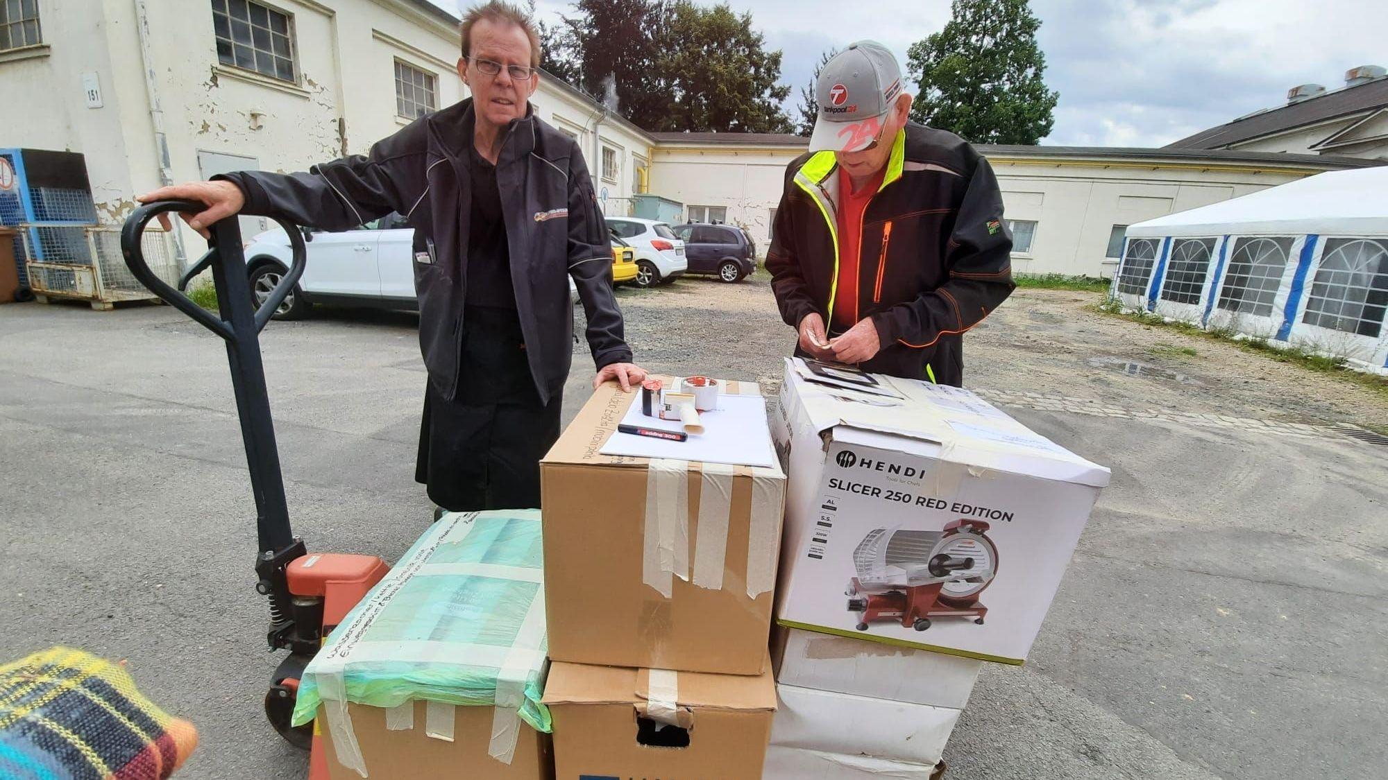Helfer beluden in Troisdorf einen Bus, der sich anschließend auf den Weg nach Slowenien machte. MIt der Ameise fuhren sie Kartons aus dem Lager zu dem Fahrzeug.