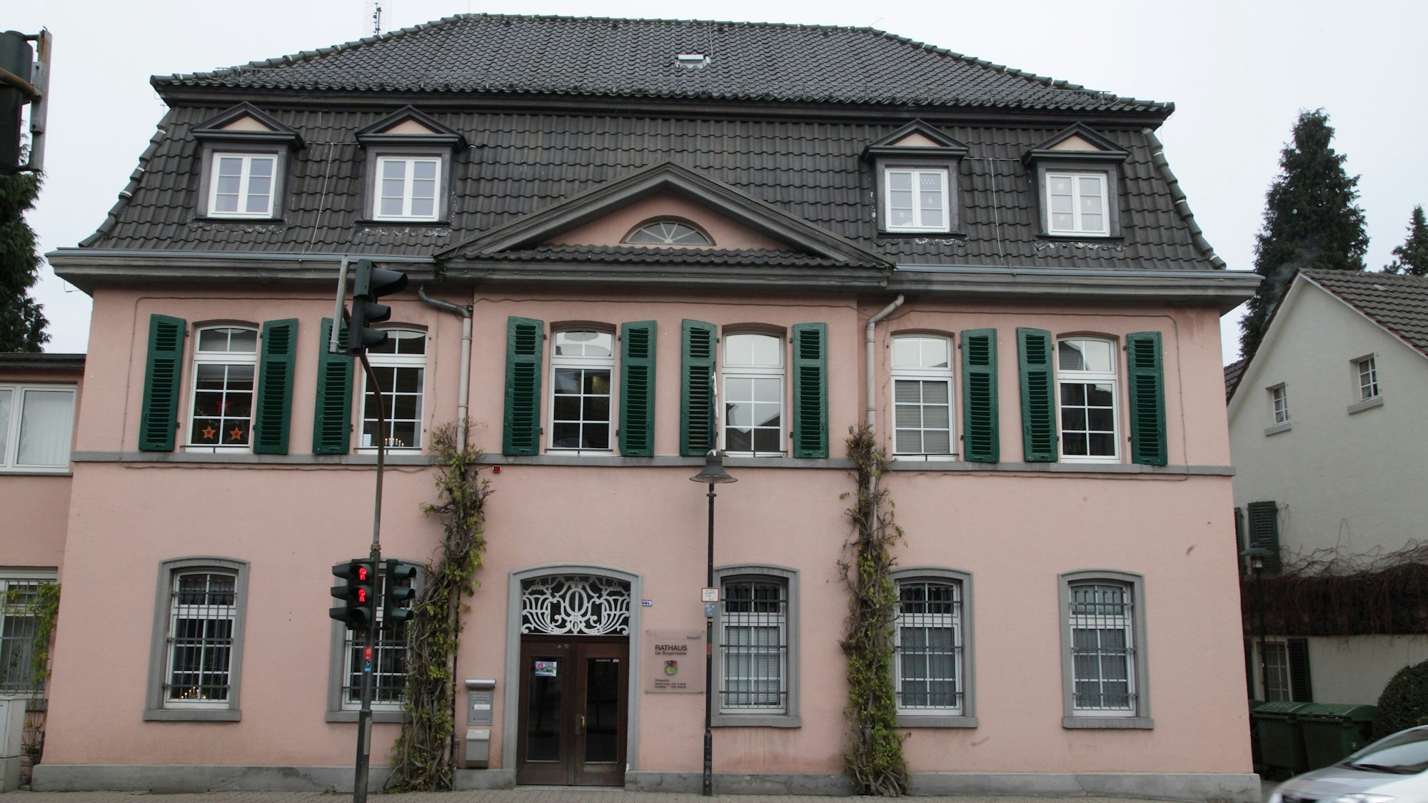 Das Rathaus in Rösrath. Ein historisches Gebäude mit Walmdach und rosa Fassade