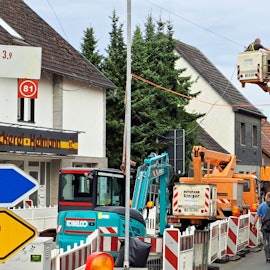 Bauarbeiter arbeiten auf der teilweise gesperrten Bensberger Straße (L 136) in Overath-Heiligenhaus.